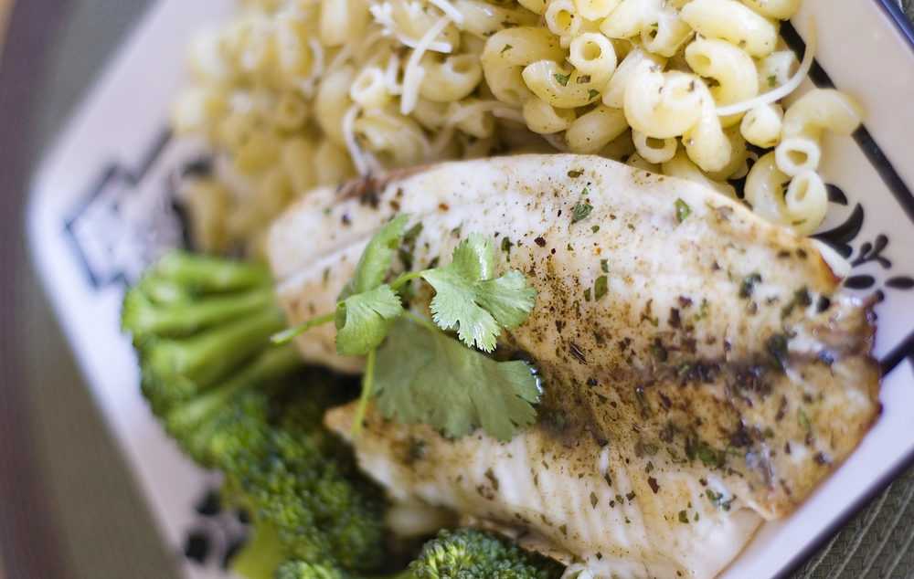 Tilapia fillet topped with spices and cilantro served with macaroni and broccoli
