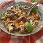 Beef cubed mixed with sliced mushrooms, celery and carrot cubes in yellow soup