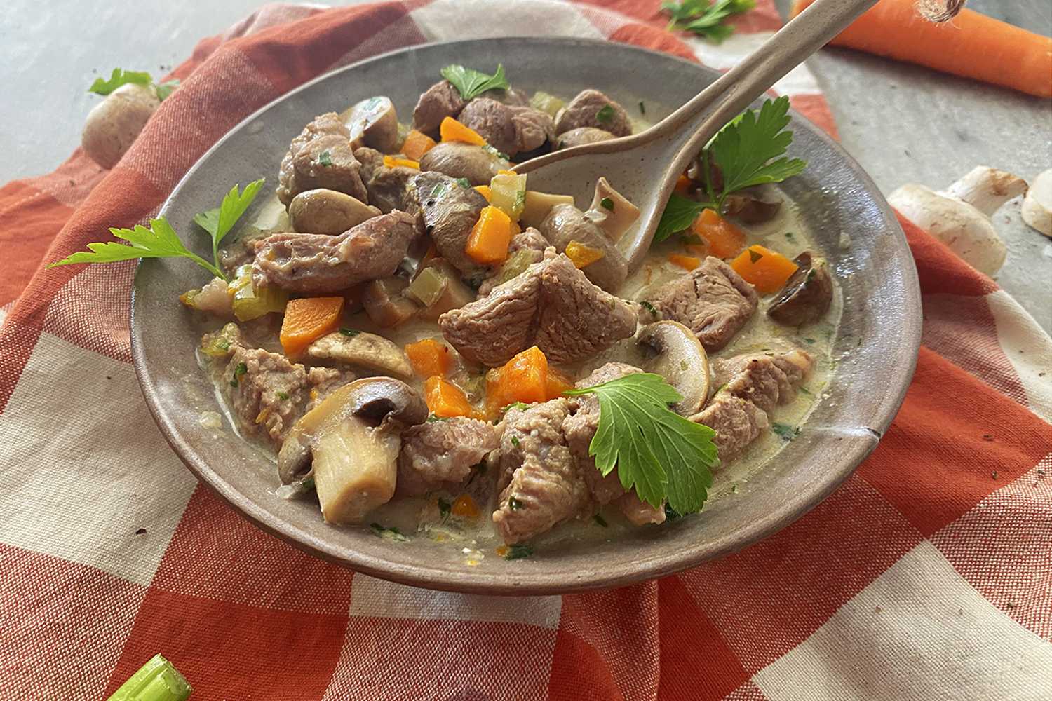 Beef cubed mixed with sliced mushrooms, celery, parsley and carrot cubes in yellow soup
