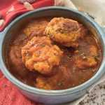 Chicken Meatballs in tomato sauce in a blue bowl with oregano on top