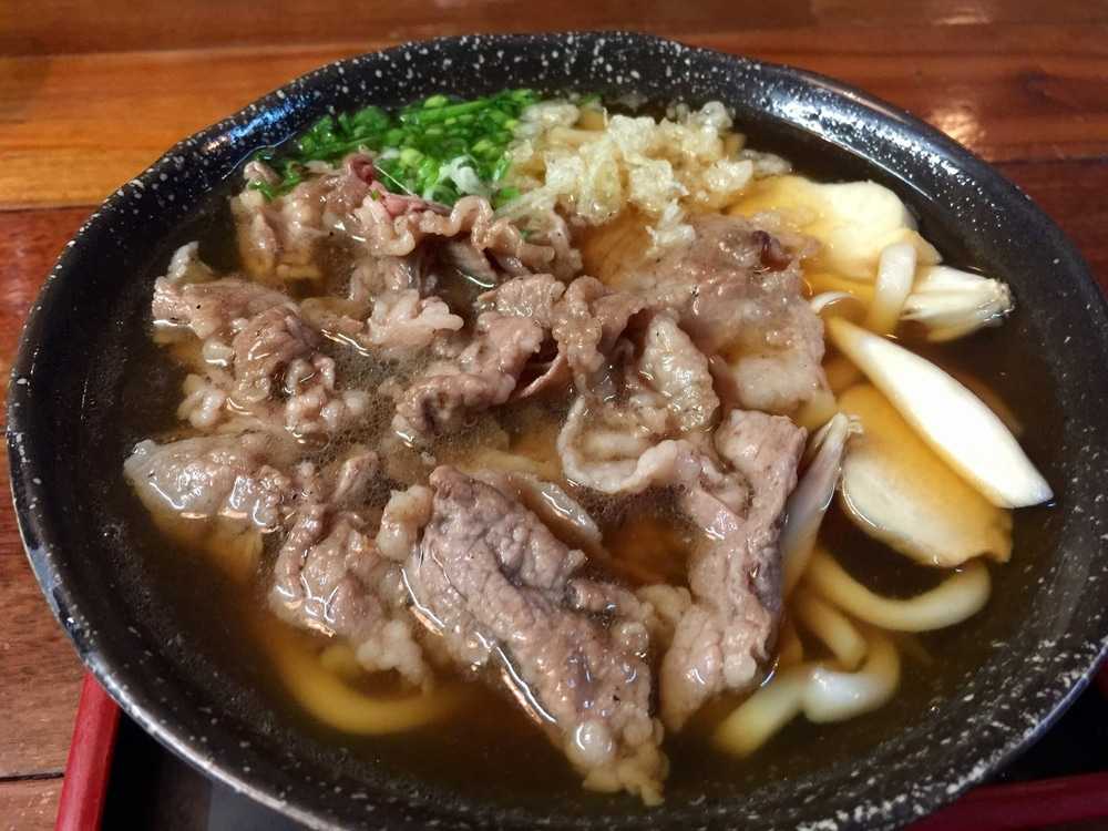 Udon noodles with beef chunks, chives and cabbage in ramen soup