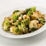 White bowl filled with roasted broccoli and cauliflower florets