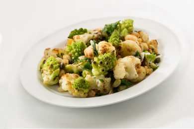 White bowl filled with roasted broccoli and cauliflower florets