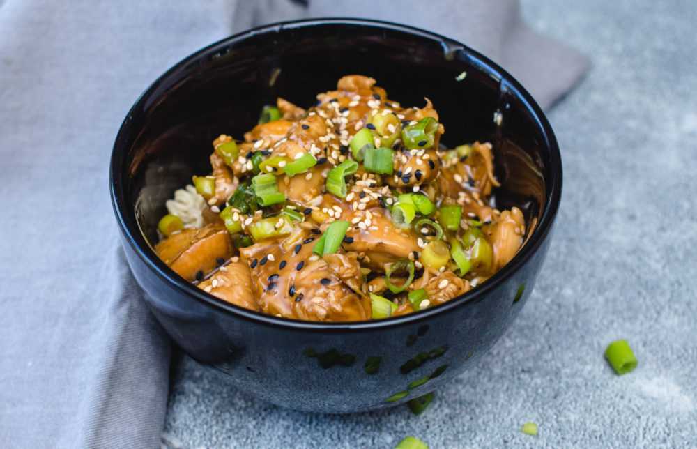 Chicken in teriyaki sauce topped with chopped scallion and white and black sesame.