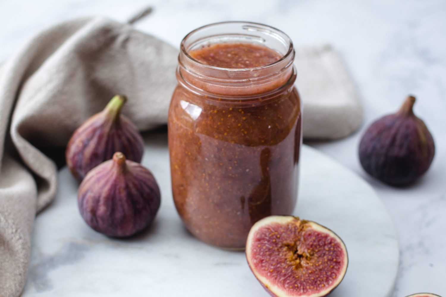 Fig jam in a jar alongside with fresh purple figs