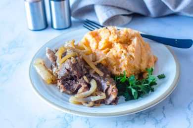 Beef roast with caramelized onions with mashed sweet potatoes and parsley on side