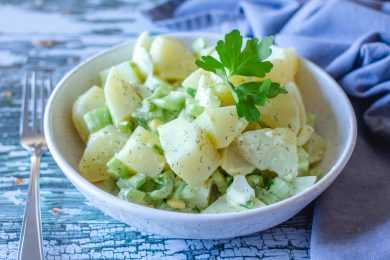 potato salad with onion and eggs and parsley leaves on top