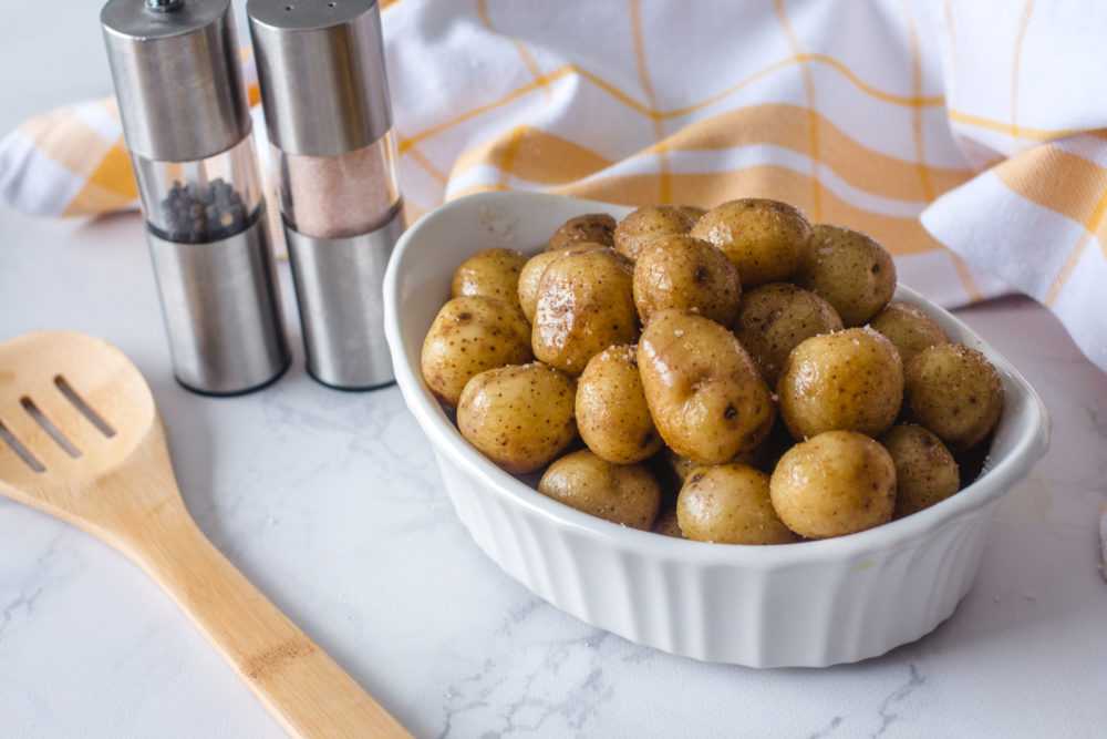 Baby Potatoes with skin topped with salt and pepper in white bowl