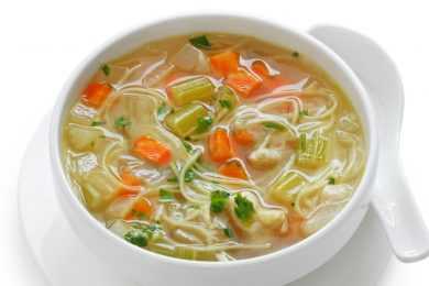 Clear soup with egg noodles, shredded chicken, celery and carrot