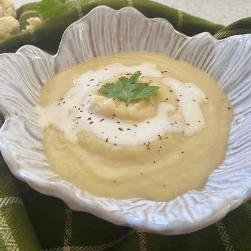 Blended cauliflower soup with cilantro and black pepper on top