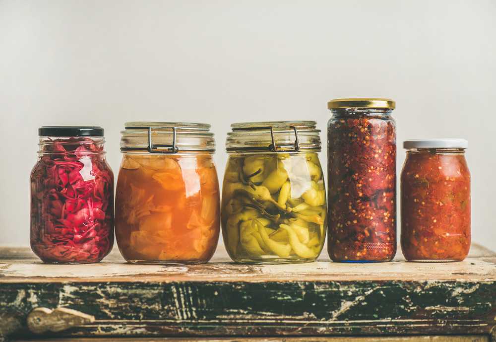 Pickles and other vegetables in jars on one line