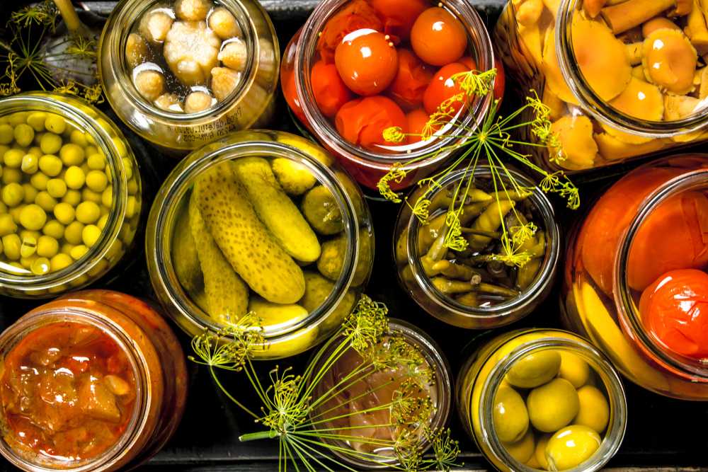 tomatoes, garlic and pickles inside jars top view