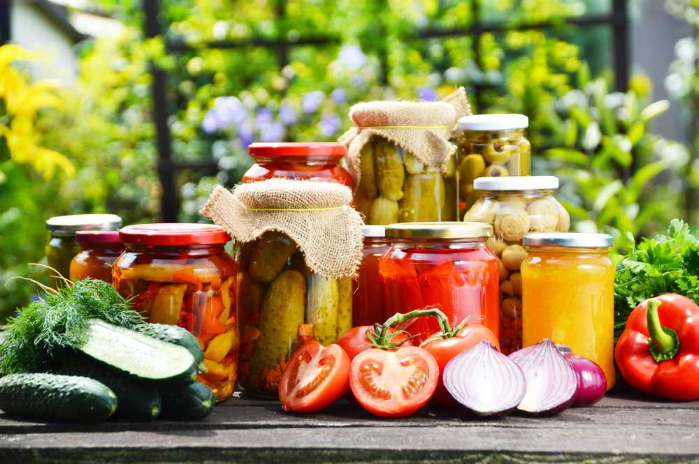 Jars with pickles, olives, tomatoes and other vegetables