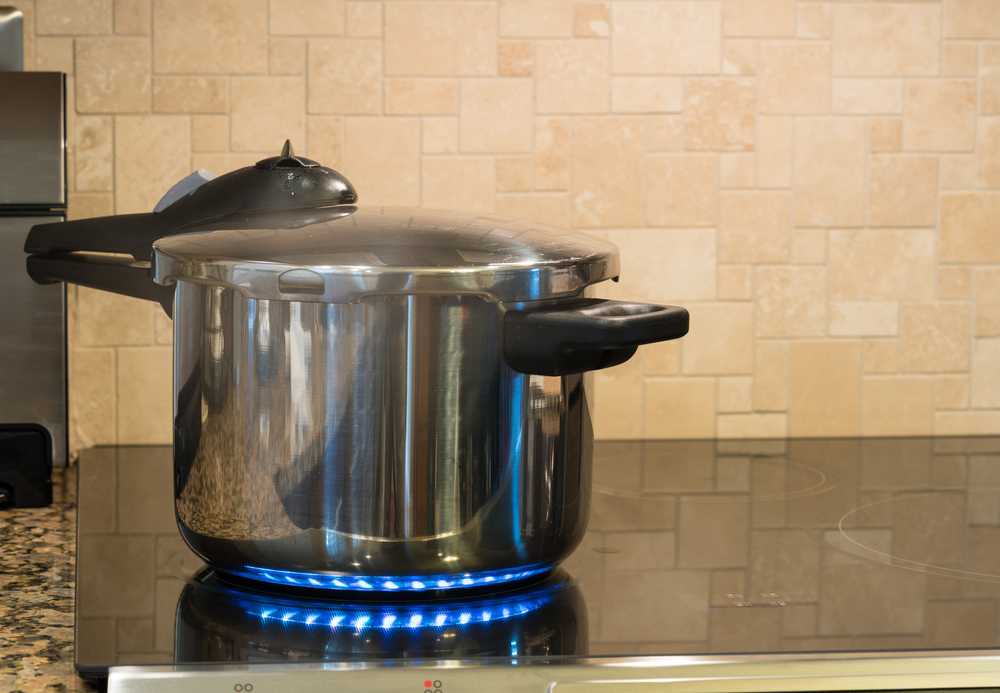black and silver pressure cooker on a glass stovetop