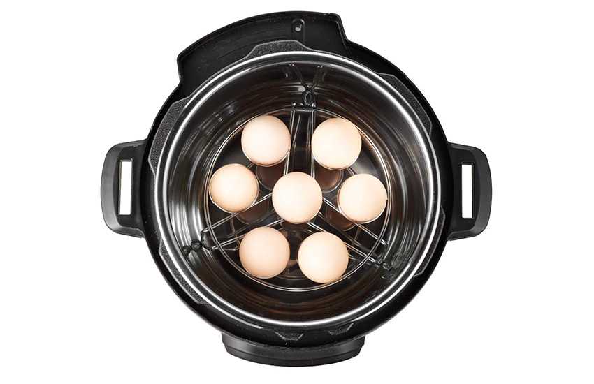 7 hard boiled eggs on a trivet inside a pressure cooker