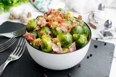 brussels sprouts mixed with chopped bacon in white bowl