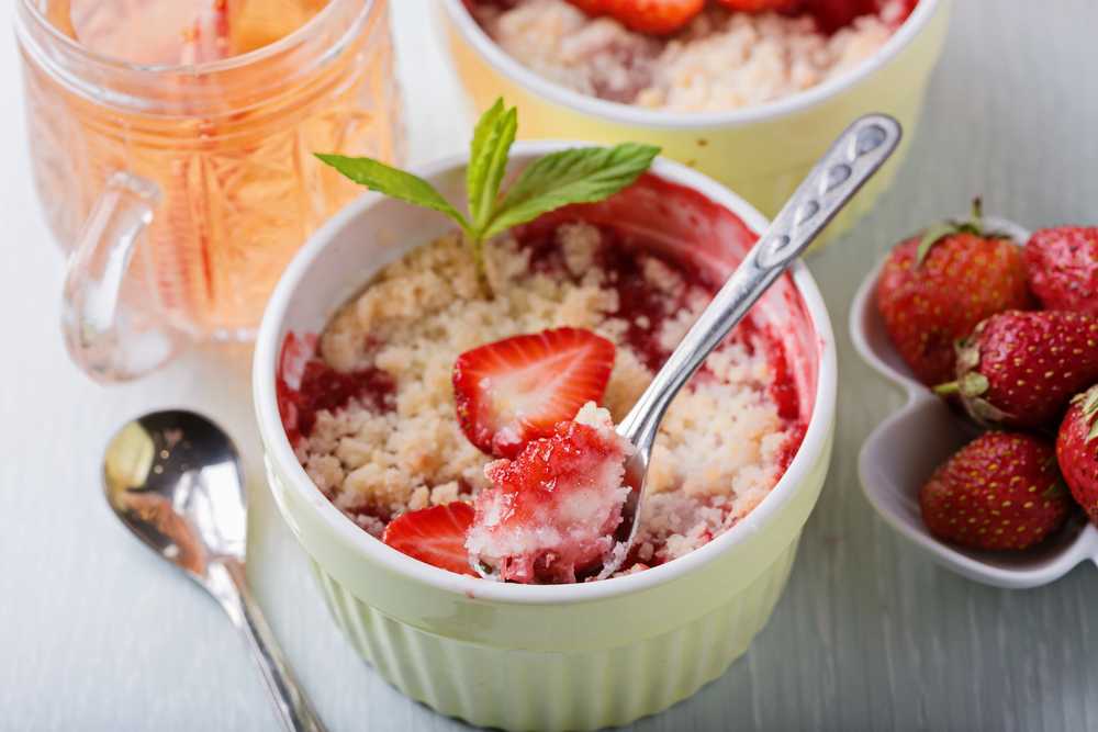 Strawberry cobbler with bread crumbs and sliced strawberries n top with mint leave and spoon inside