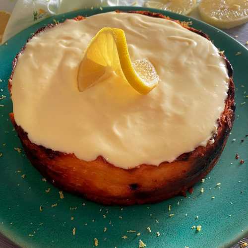 Baked cheesecake with buttercream frosting and a slice of lemon on top