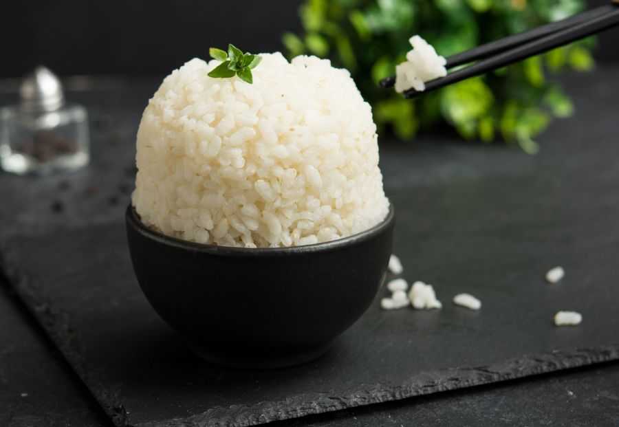 Basmati rice in a black bowl topped with basil