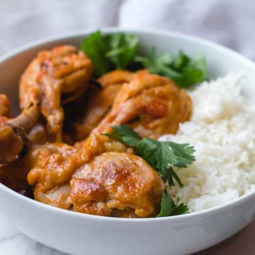 Chicken Drumsticks in red sauce served with white rice and fresh parsley