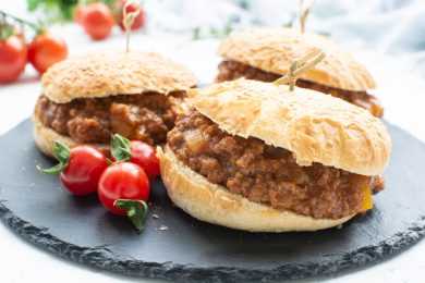 three buns with ground beef with tomato sauce near cherry tomatoes