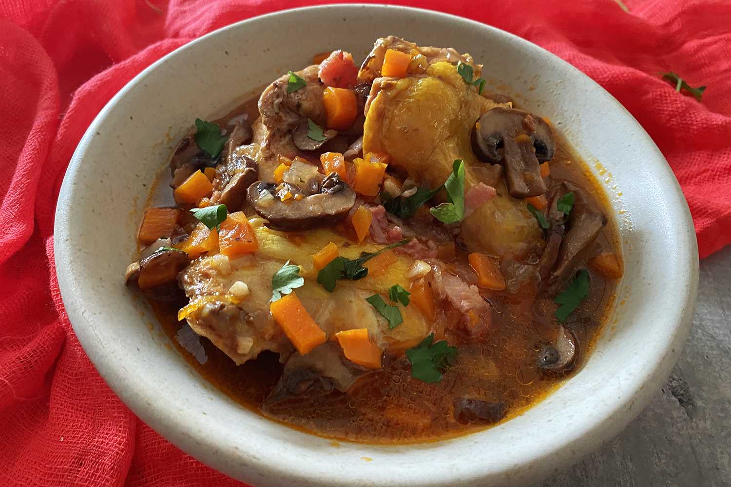 Hühnerfleisch in einer braunen Suppe gefüllt mit Karottenwürfeln, Champignons, Speck und gehackter Petersilie