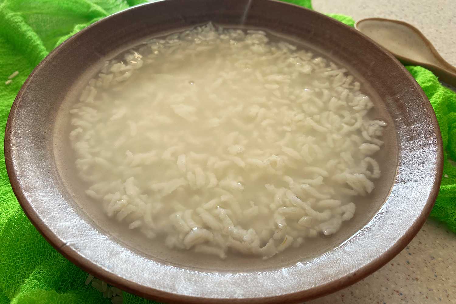 Brown bowl filled with cooked rice and water 