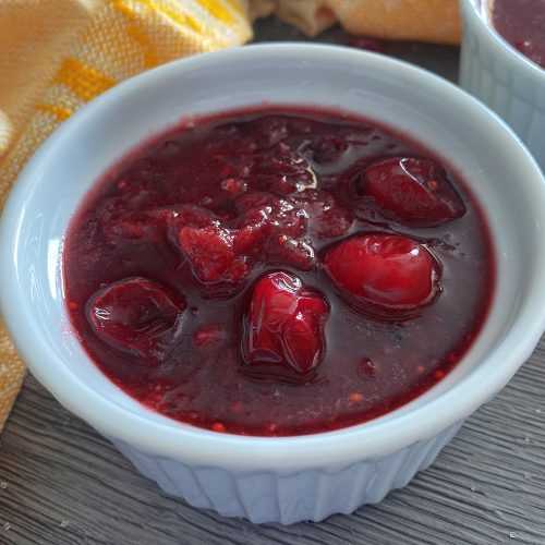 purple-red sauce in a small white bowl filled with cranberries