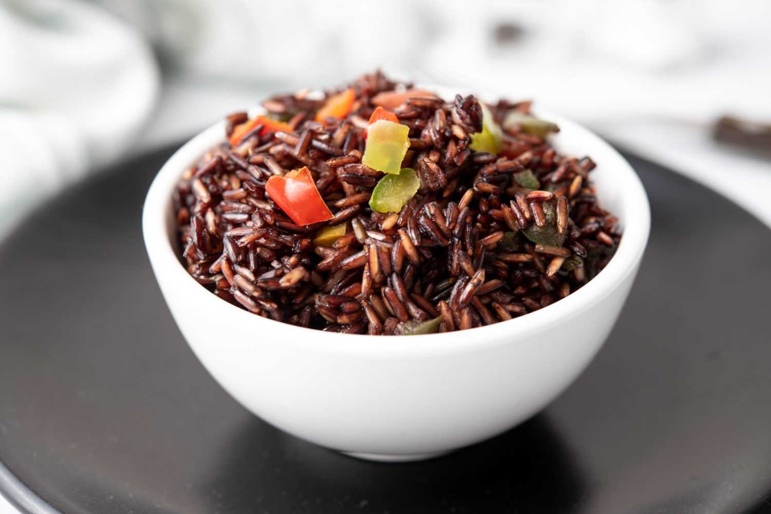Black rice mixed with red and green bell pepper cubes 