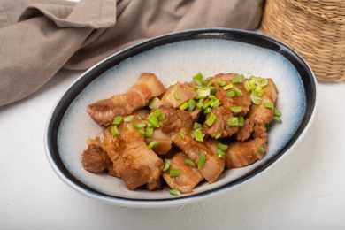 pork belly braised in caramel sauce with scallion on top
