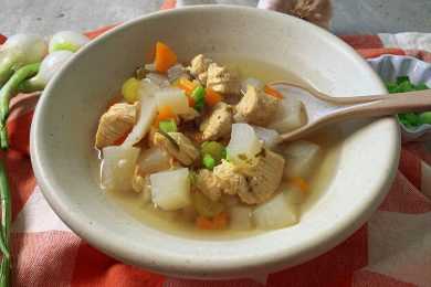 Chicken Soup with potato and carrot cube and brown spoon insides