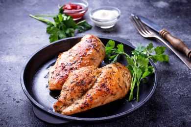Chicken breasts topped with herbs with parsley on side