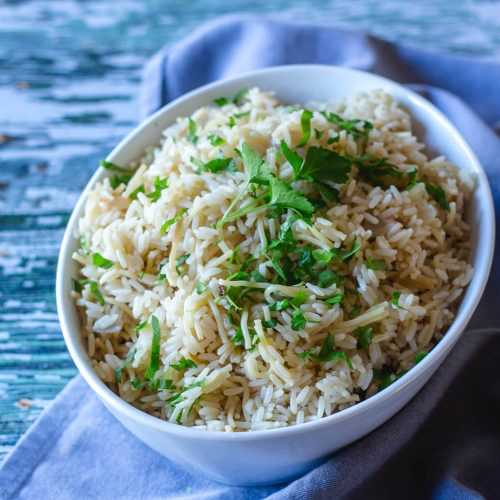 Rice with crushed spaghetti noodles with chopped parsley in white bowl