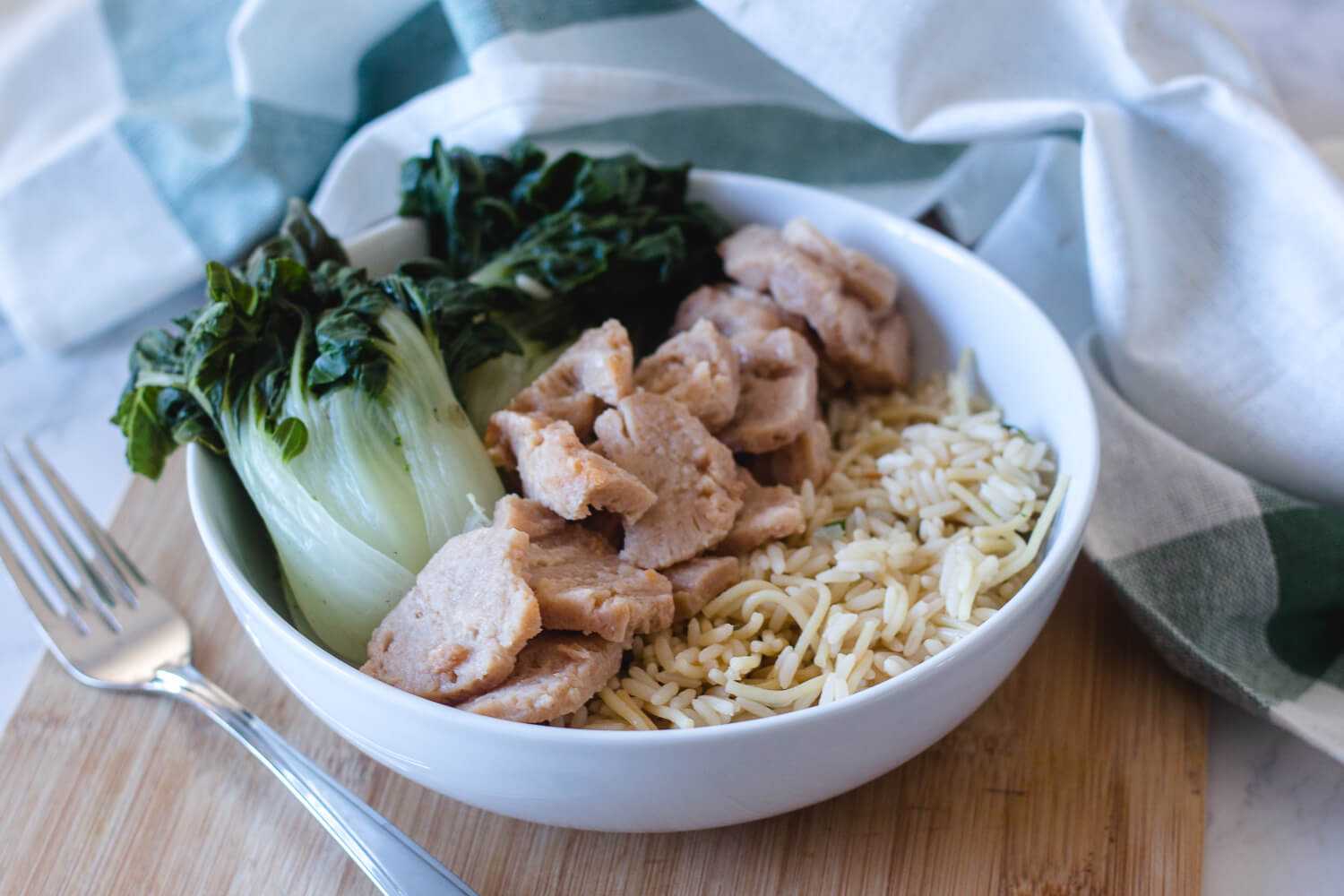 Seitan chunks served with rice a roni and seamed bok choy