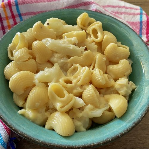 Macaroni and cheese mixed with cauliflower in blue bowl