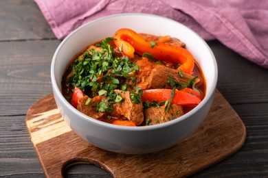 Lamb cubes in red sauce with bell pepper, carrots and parsley