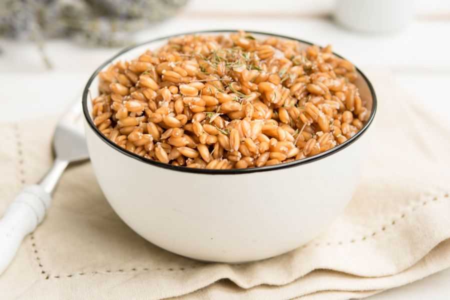 Farro in white bowl topped with spices