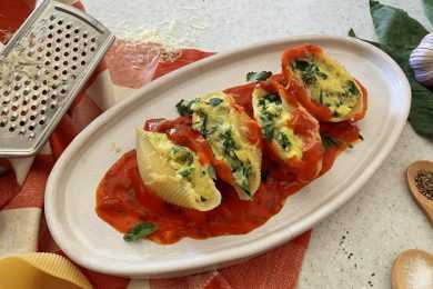 big pasta shells filled with mozzarella cheese and spinach laying on red marinara sauce