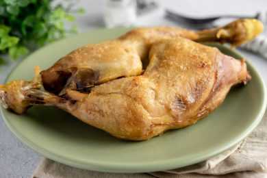 Two chicken leg quarters roasted in green plate
