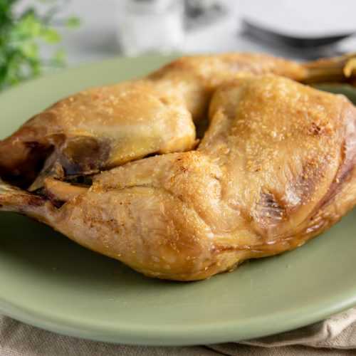 Two chicken leg quarters roasted in green plate