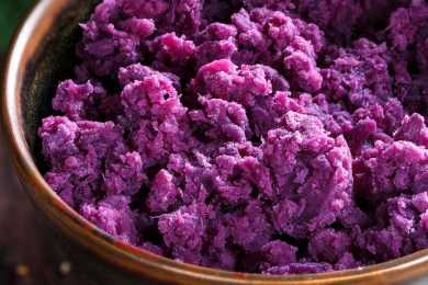 Mashed purple potatoes in brown bowl