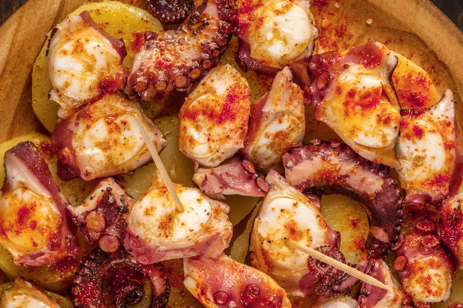 Roasted octopus pieces topped with paprika with toothpicks