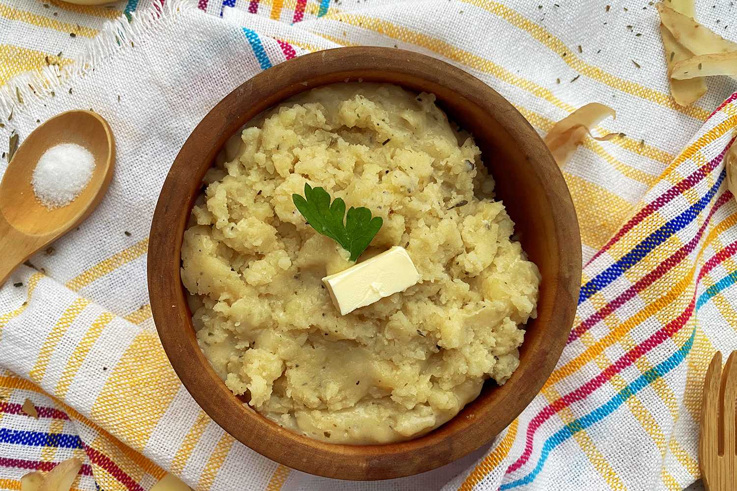 brown bowl full of creamy mashed potatoes topped with butter 