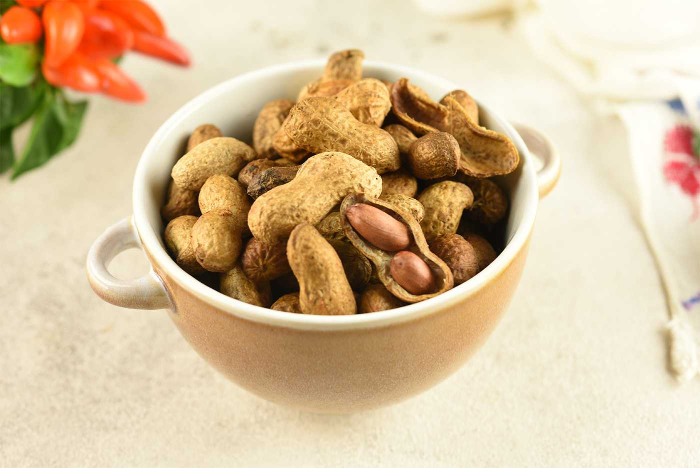 peanuts with shells inside a cup top view