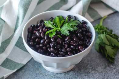 Black beans topped with parsley in white bowl