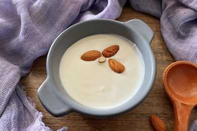 almond milk yogurt with 3 almonds inside in a gray bowl