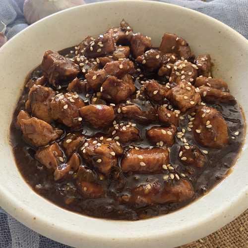 Chicken cubes in honey sauce topped with sesame seeds