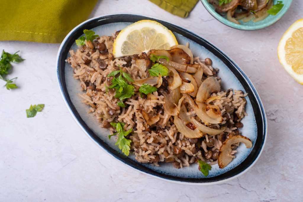 plate of instant pot lentils and rice with a lemon garnish on top 