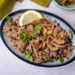 Rice with lentils topped wit caramelized onion, chopped parsley and lemon slice
