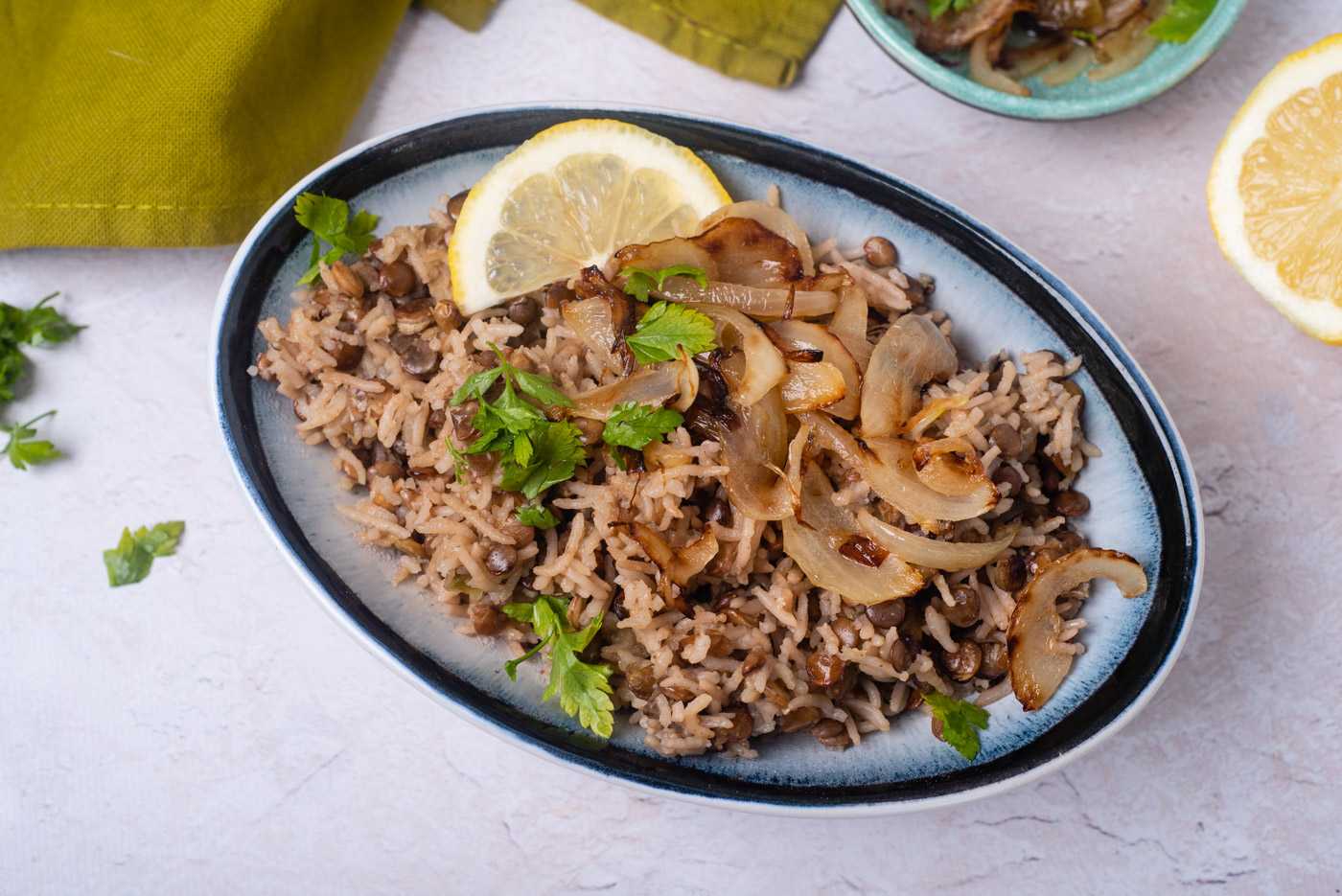 Rice with lentils topped wit caramelized onion, chopped parsley and lemon slice